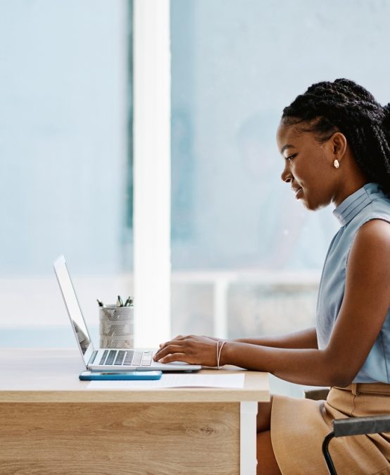 Young black businesswoman working on a laptop in an office alone